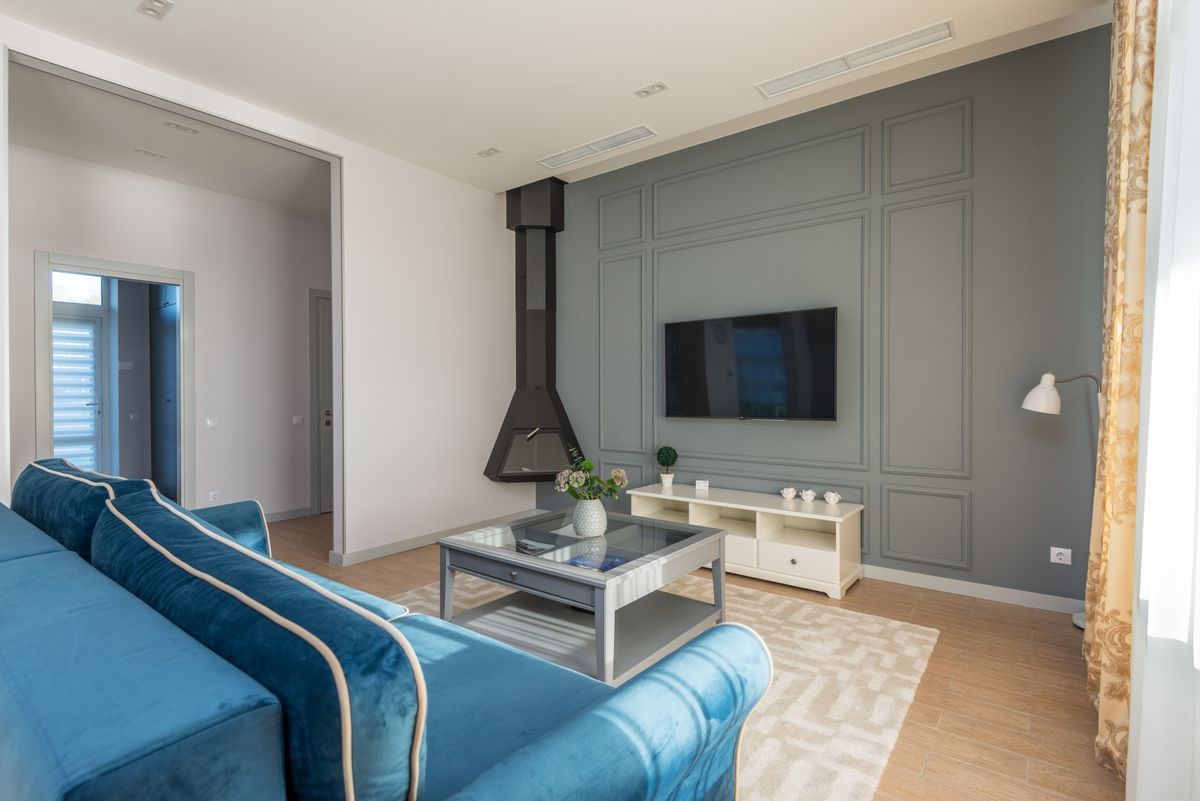 Inspiration: a wall-mounted TV in a bright living room with blue velvet sofas
