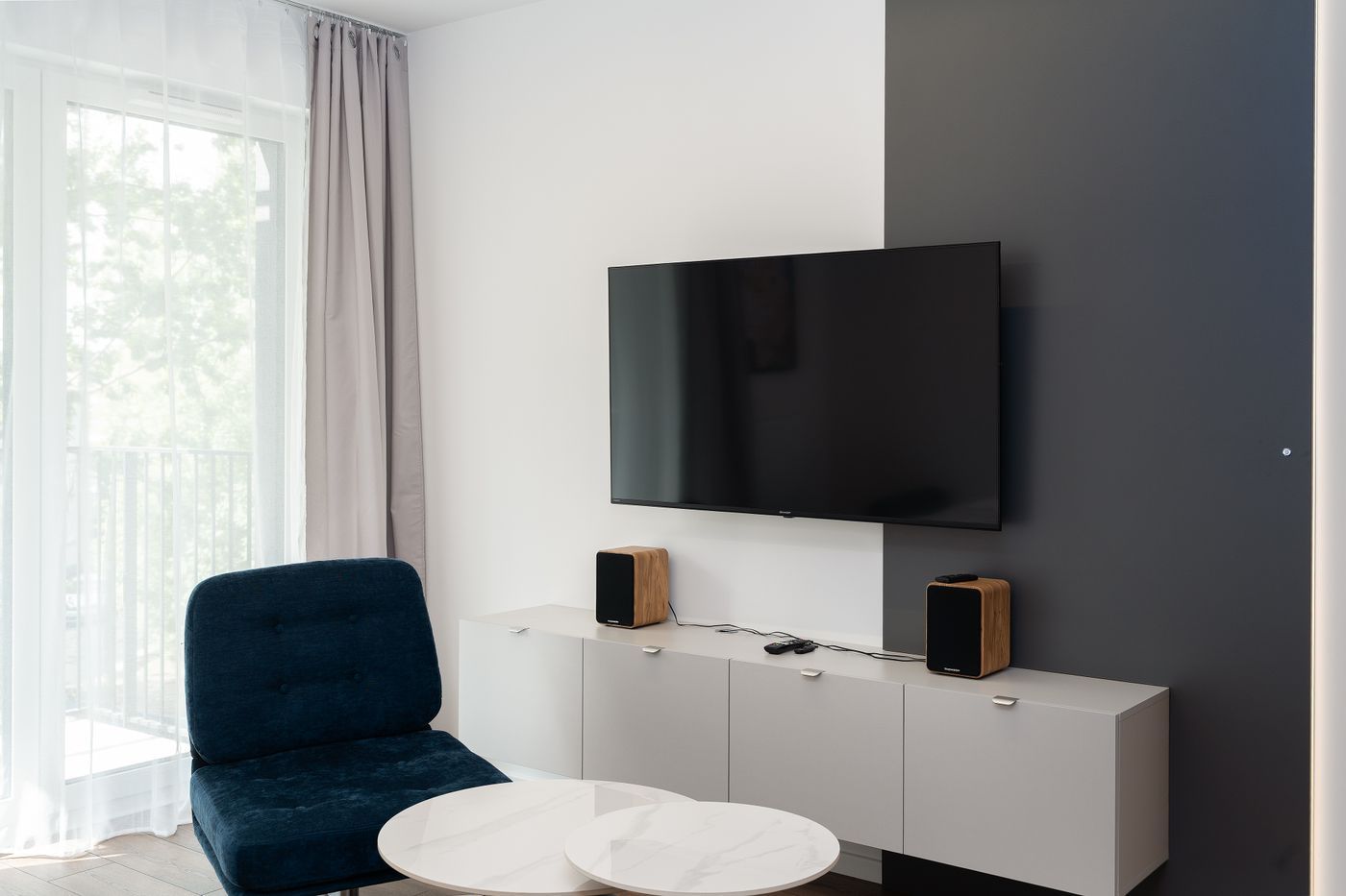A wall-mounted TV with no visible cables above a clean white media console
