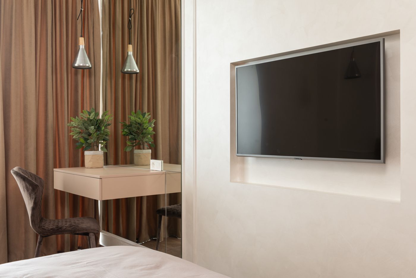 A TV mounted on the wall of a hotel room