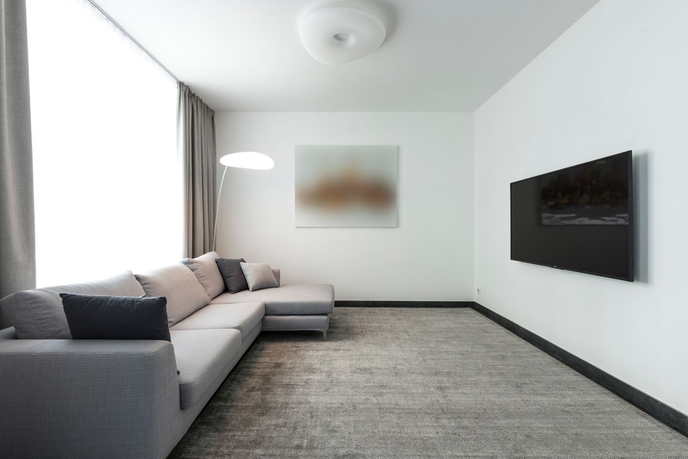 A freshly mounted TV in a bright condo living room