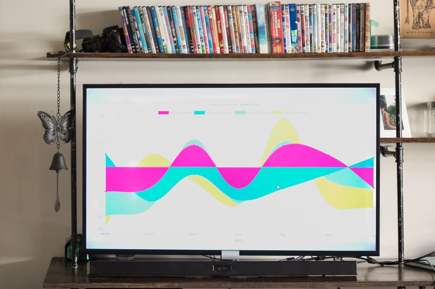 A smart TV switched on and set up above a media shelf